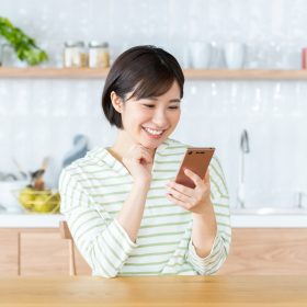 笑顔でスマホを操作する女性