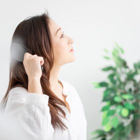 ブラシで髪をとかす女性