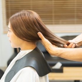 美容室で髪をみてもらう女性