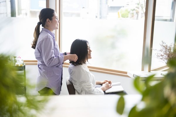 美容室で美容師と話す女性客