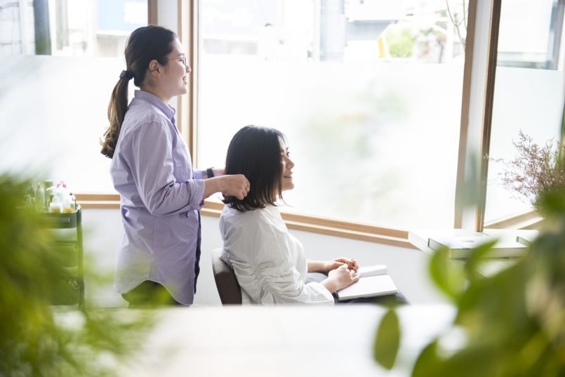 美容室で美容師と話す女性客