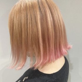 金髪からピンクのグラデーションヘアの女性