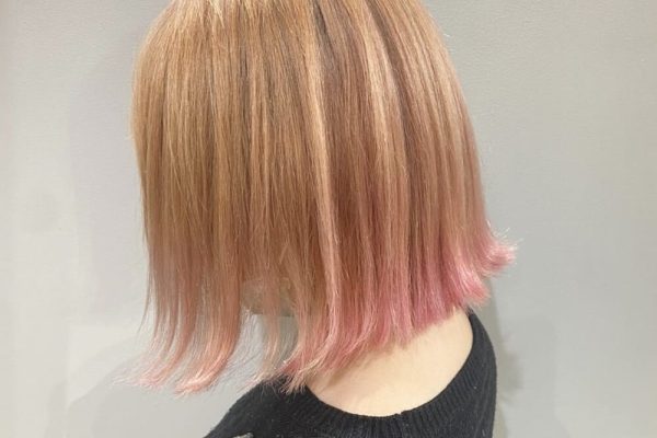 金髪からピンクのグラデーションヘアの女性