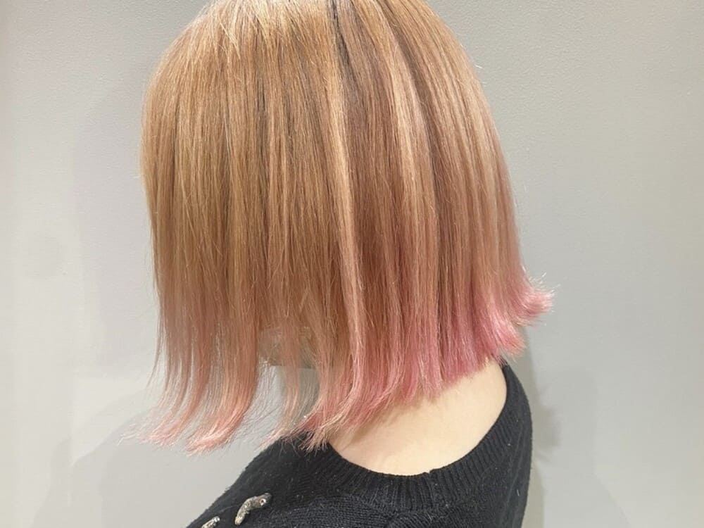 金髪からピンクのグラデーションヘアの女性